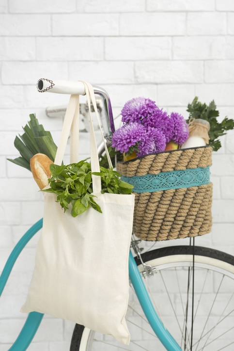 Türkises Fahrrad mit Einkaufstasche hängend über dem Lenkrad.