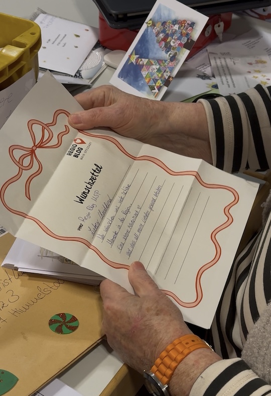 Frau hält Wunschzettel in der Hand.