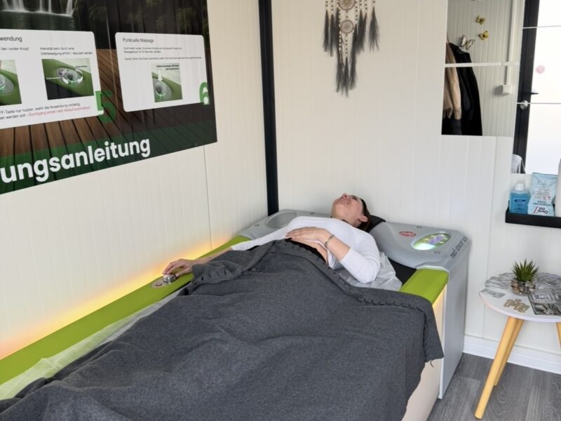 Frau liegt auf einer Hydro-Massage-Liege in em RelaxCube.