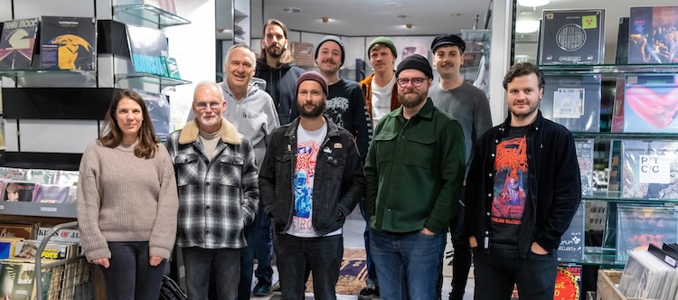 Das Team der Plattentruhe lächelt stehend in die Kamera.