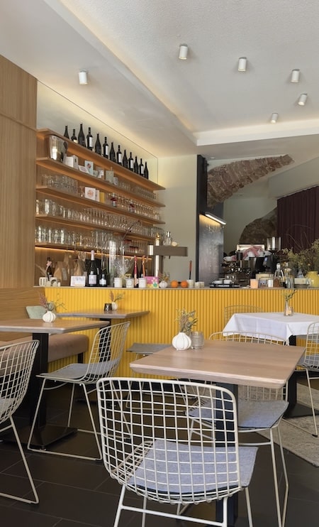 Fiore von Innen mit gelber Bar und Backsteinen an den Wänden.